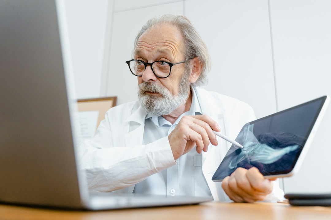 older man doctor showing an xray of a foot to a video camera