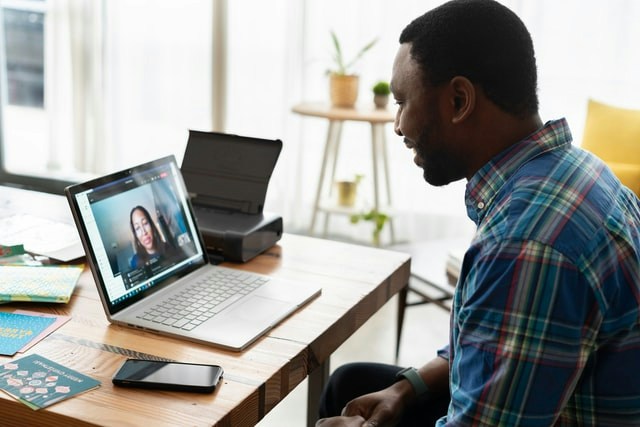 Man looking at a computer during an online meeting
