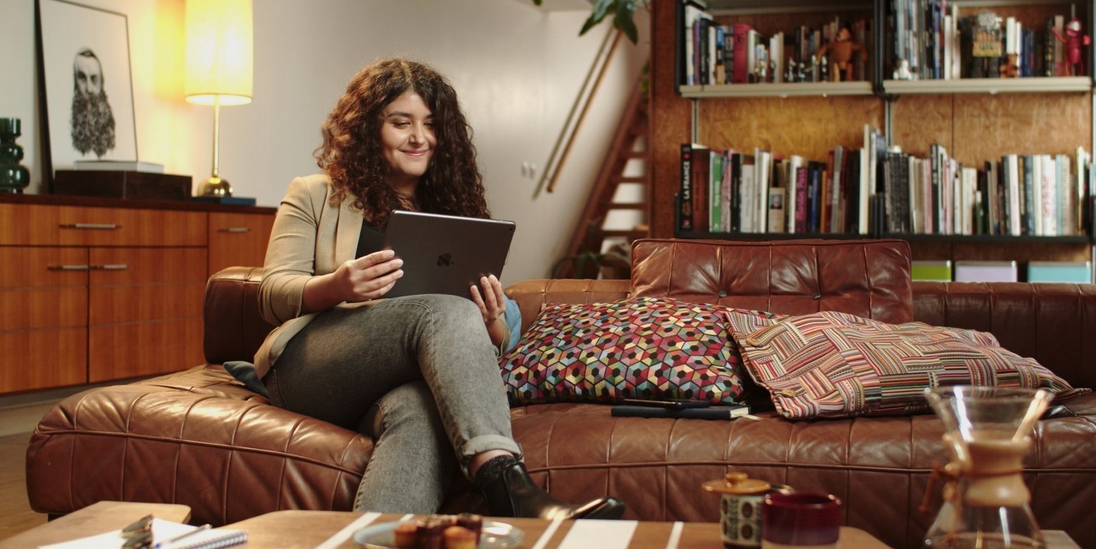 Girl smiling as she's studying from her tablet