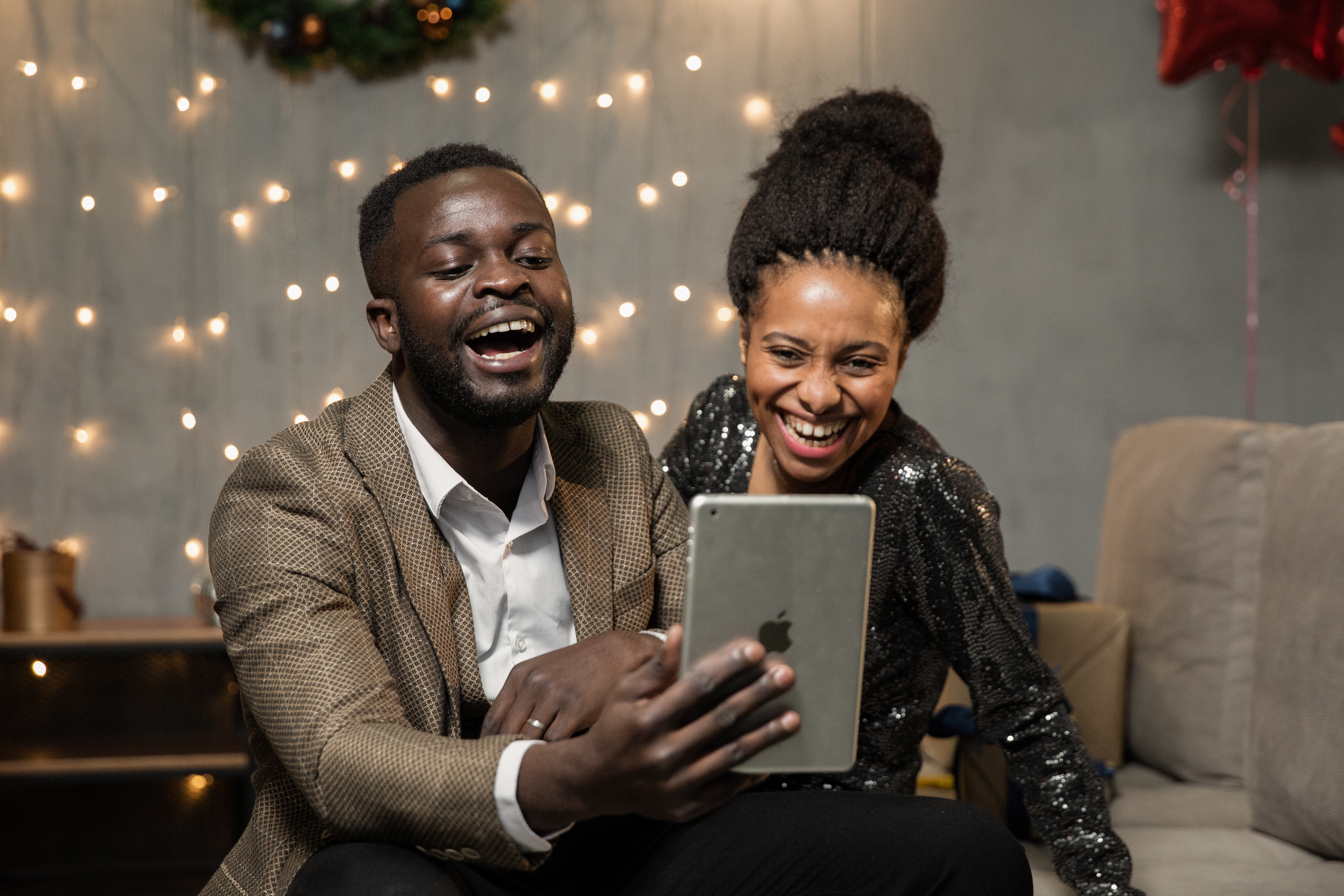 couple participating in fun virtual event with others on their team and project, but remotely through their phone and tablets