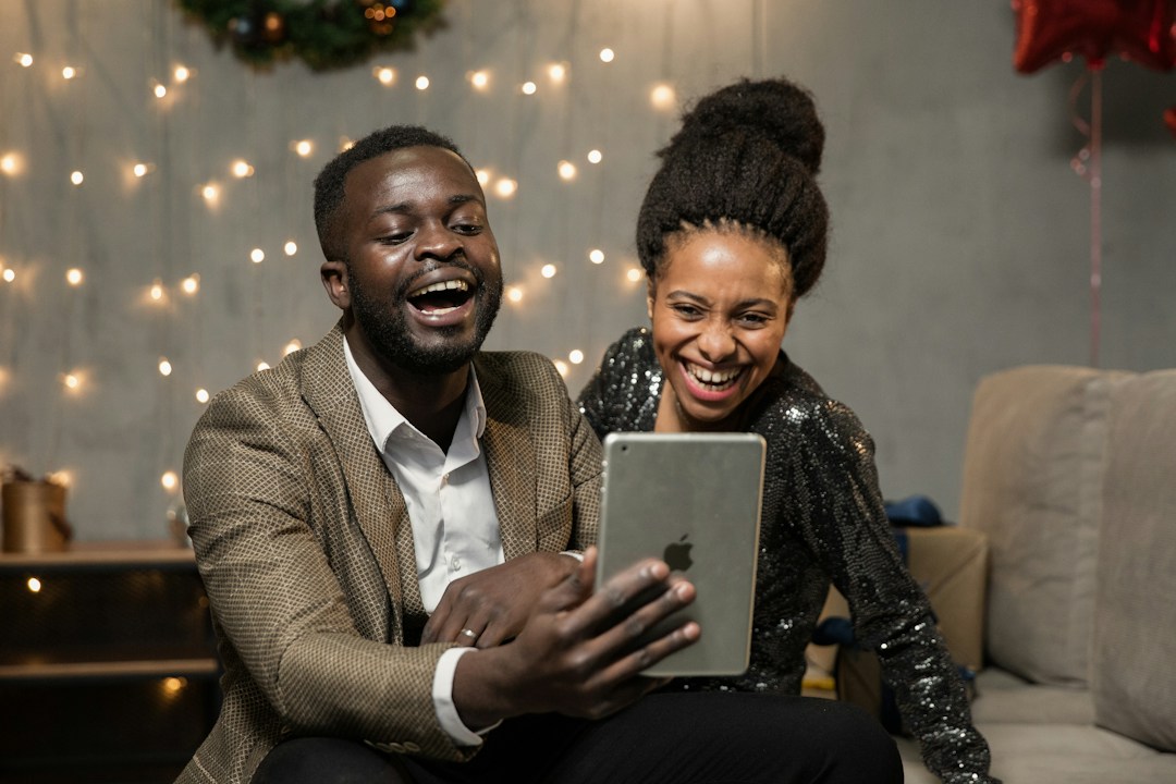 couple participating in fun virtual event with others on their team and project, but remotely through their phone and tablets