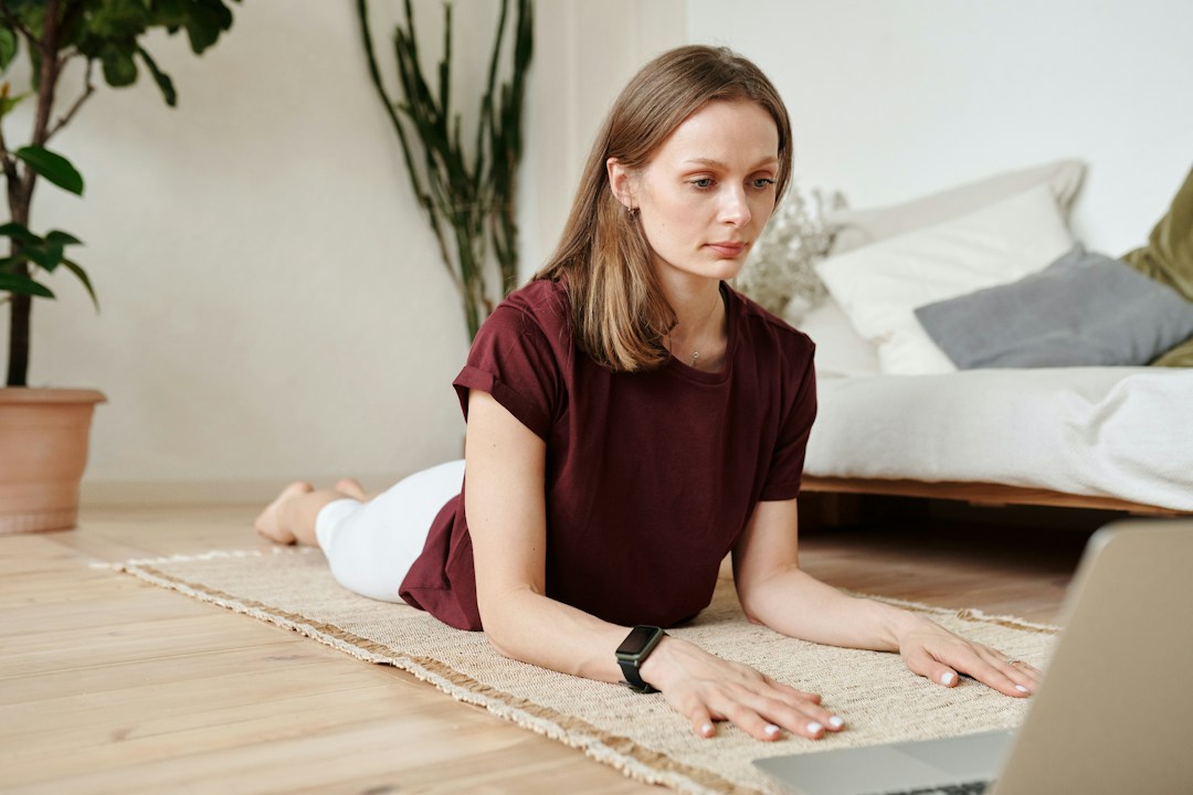 A woman doing yoga online with an instructor and the rest of her work team as part of a team building and fun activity