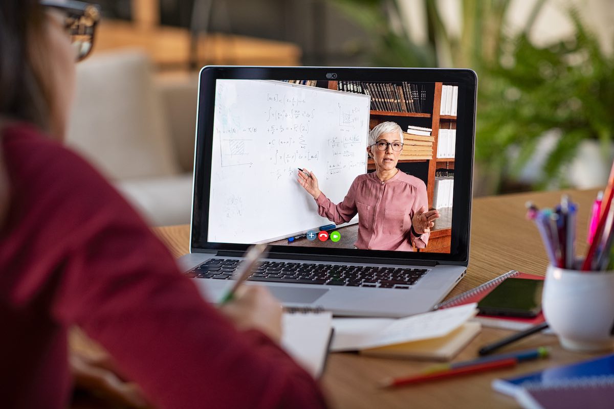 woman wearing red shirt looking at a virtual lesson 