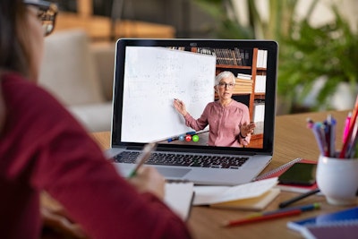 woman wearing red shirt looking at a virtual lesson