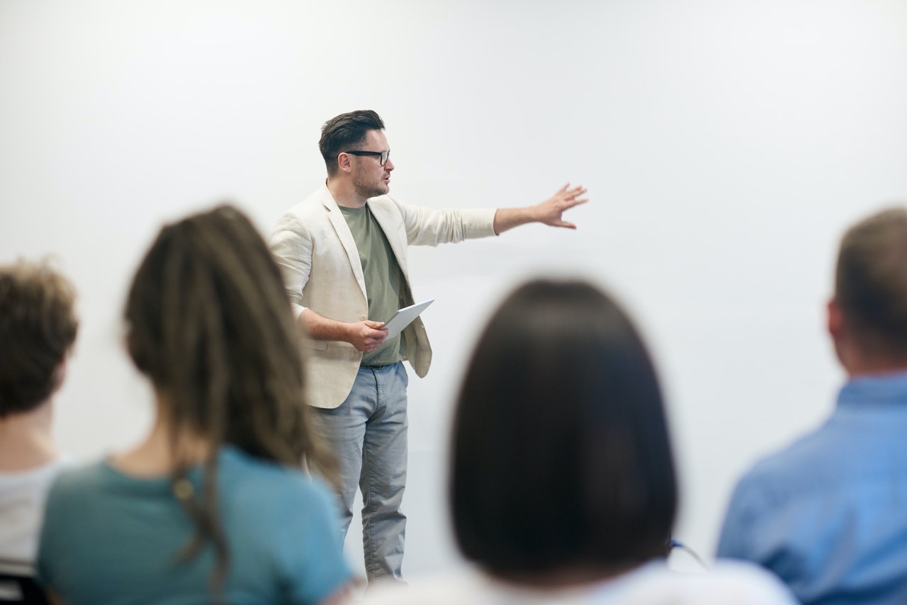 hombre dando presentación a grupo en aula moderna