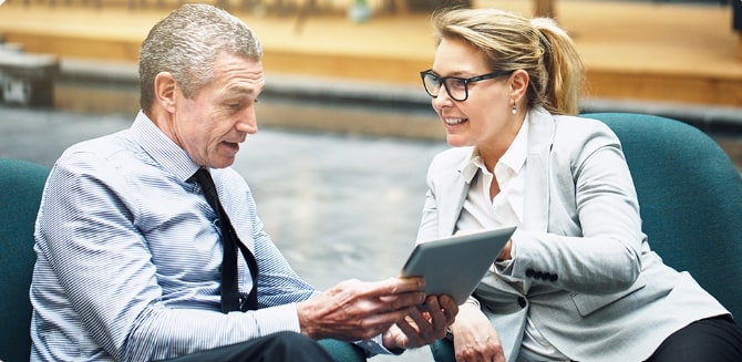 Internal corporate communications: a woman showing a man a report