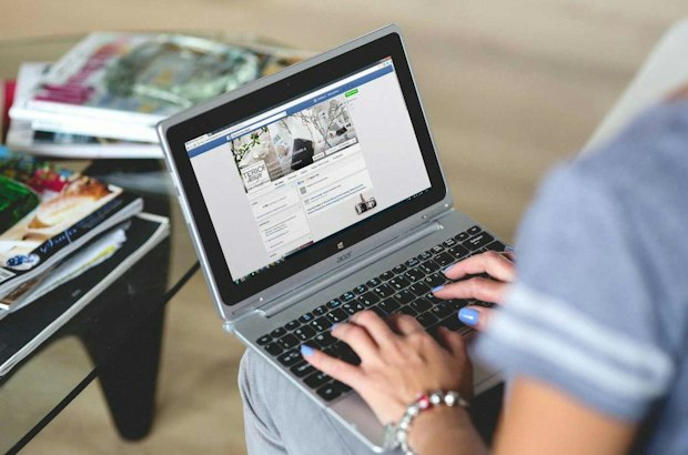 Woman using Facebook on a laptop