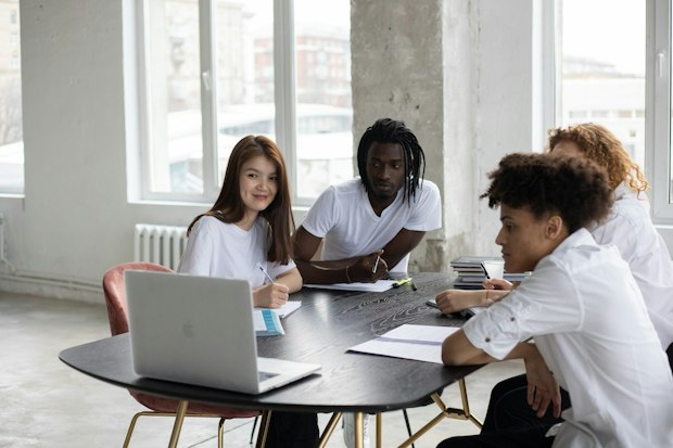 groupe d'étudiants travaillant ensemble autour d'un ordinateur portable