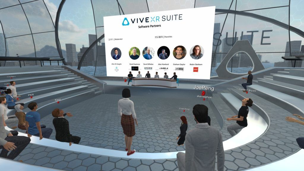 A virtual meeting space in HTC Vive with various avatars sitting in a semicircle watching an online event on a screen.