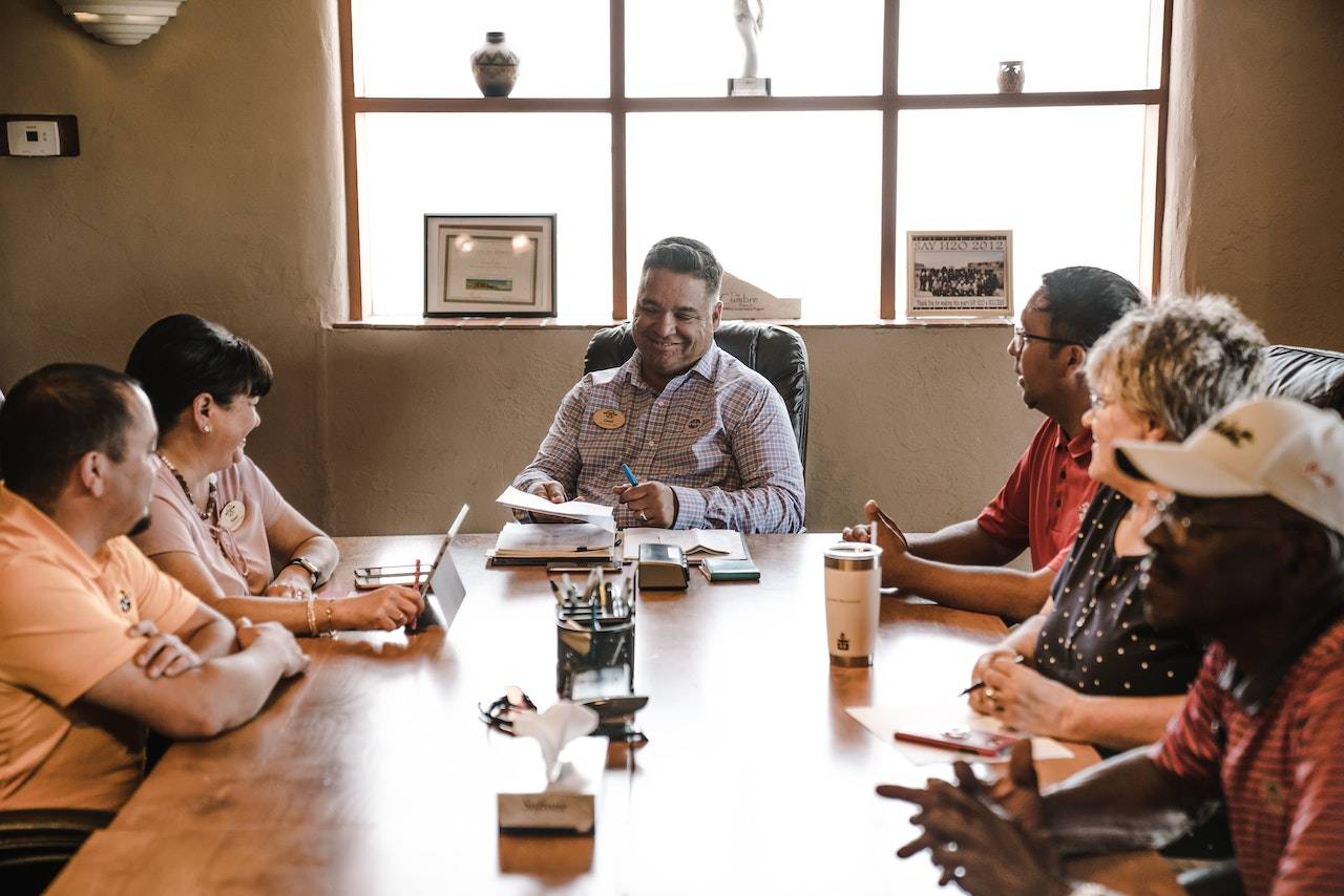 Six people having a sales meeting in person