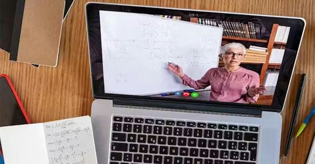 la pantalla de un portátil muestra a un profesor dando una clase virtual