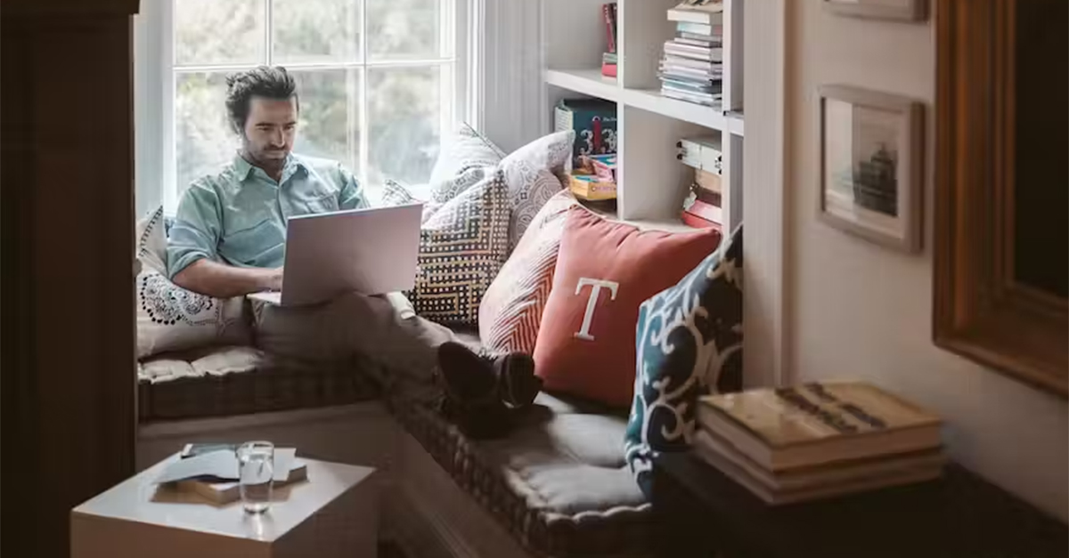 man working from home typing on a computer
