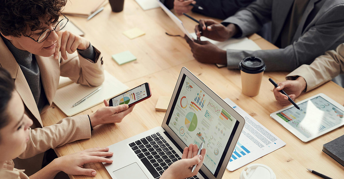 Team bespricht Datenanalysen auf digitalen Geräten