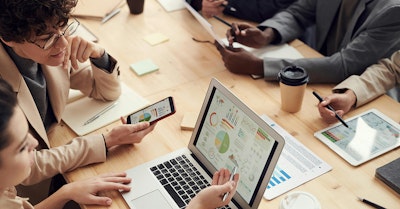 Team bespricht Datenanalysen auf digitalen Geräten