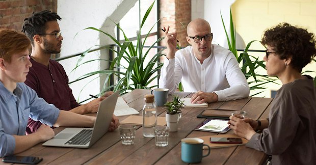 Réunion d'équipe en bureau avec laptops et café