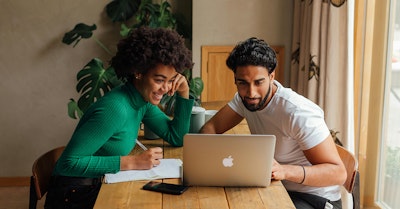 Zwei Personen arbeiten am Laptop