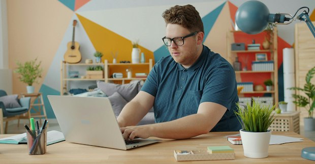 Mann arbeitet zuhause am Laptop