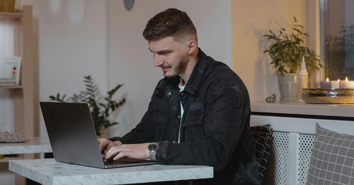 Homme travaillant sur ordinateur portable au café