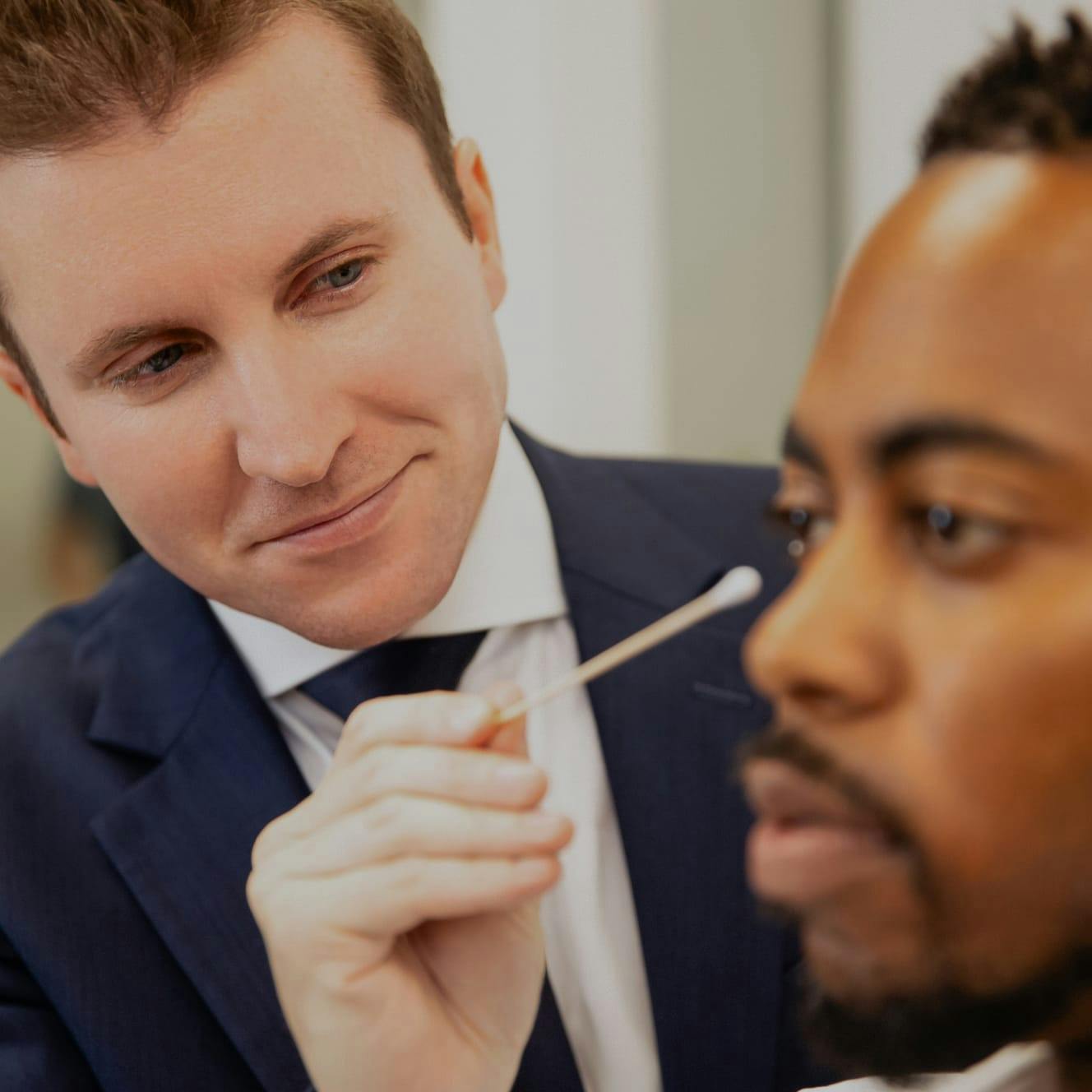 Dr. Edward Davidson pointing at a client's face with a cotton swab