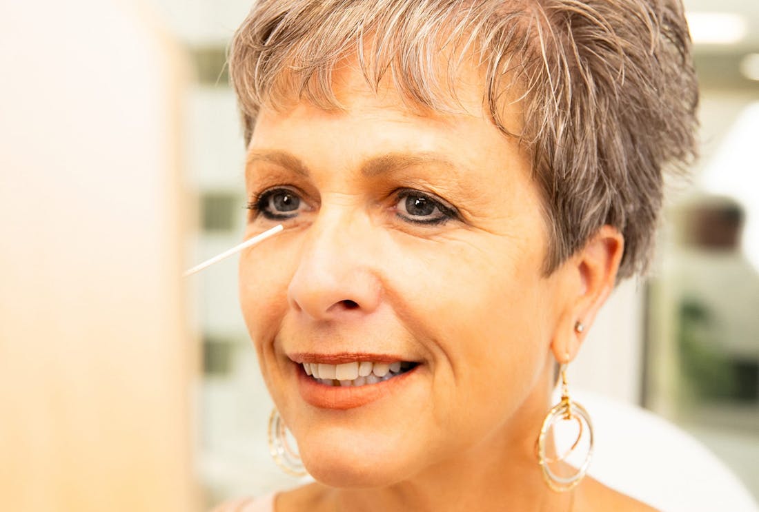 woman looking at hand mirror