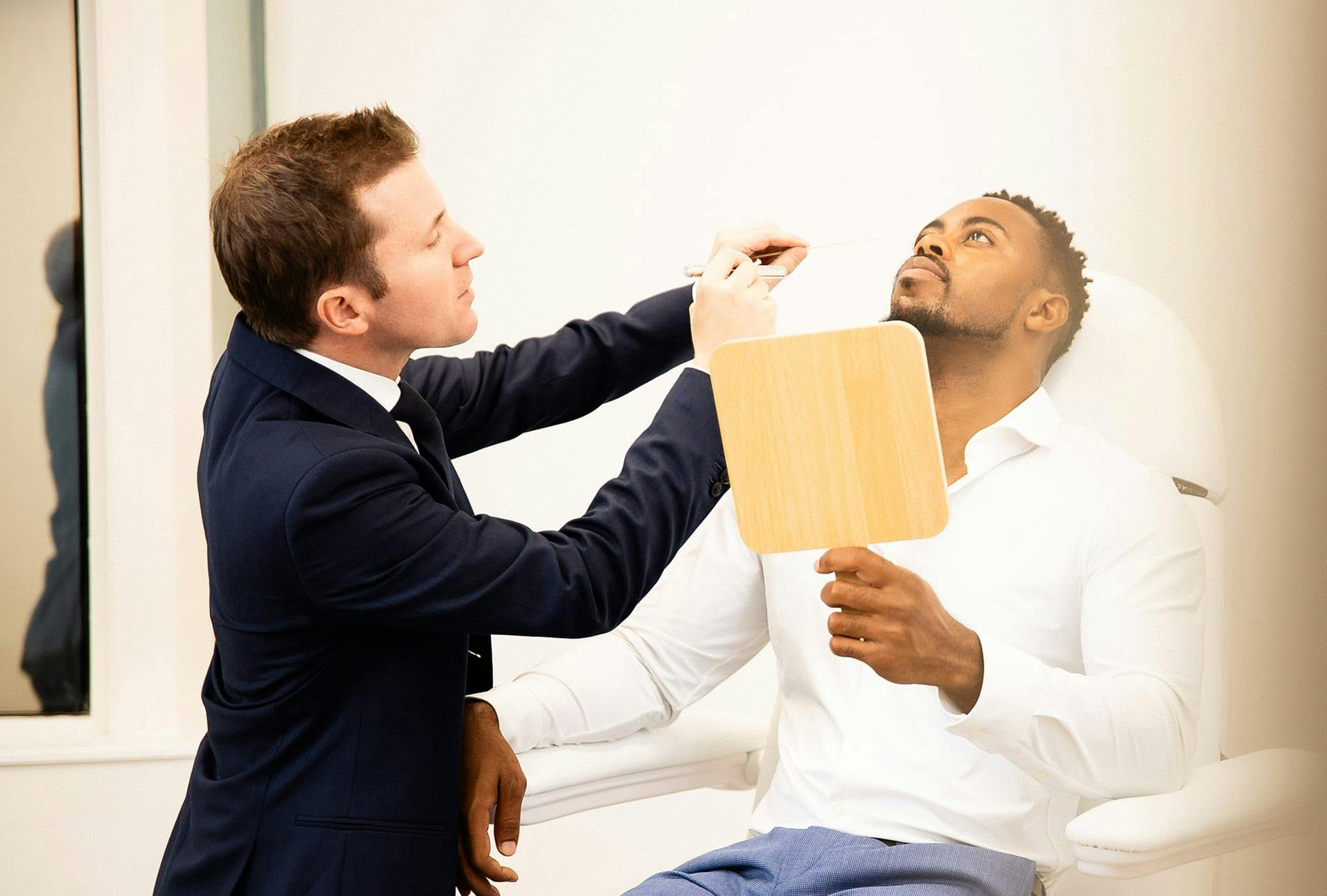 man sitting in chair, doctor greeting him