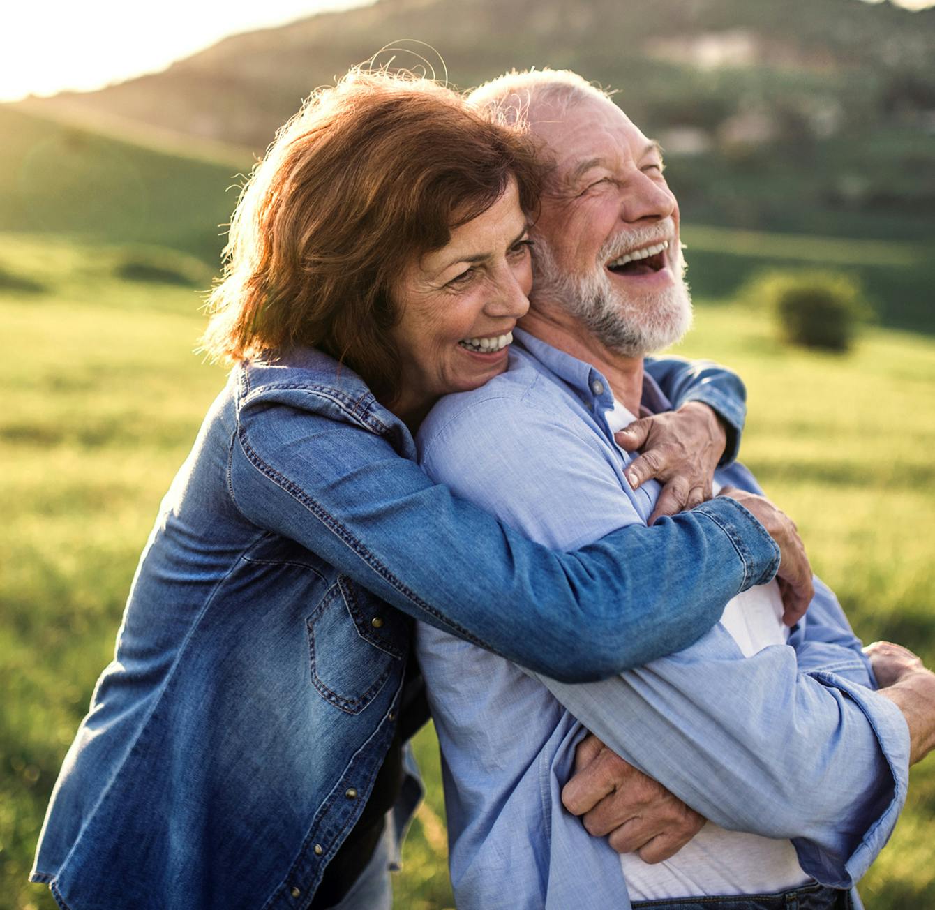 older couple embracing and laughing outside