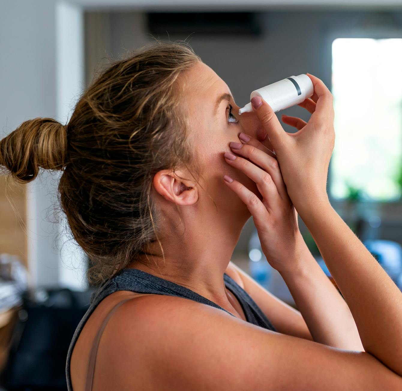 woman putting in eye drops