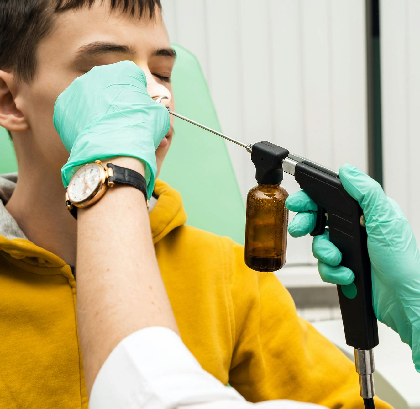 young man getting a nose exam from a doctor
