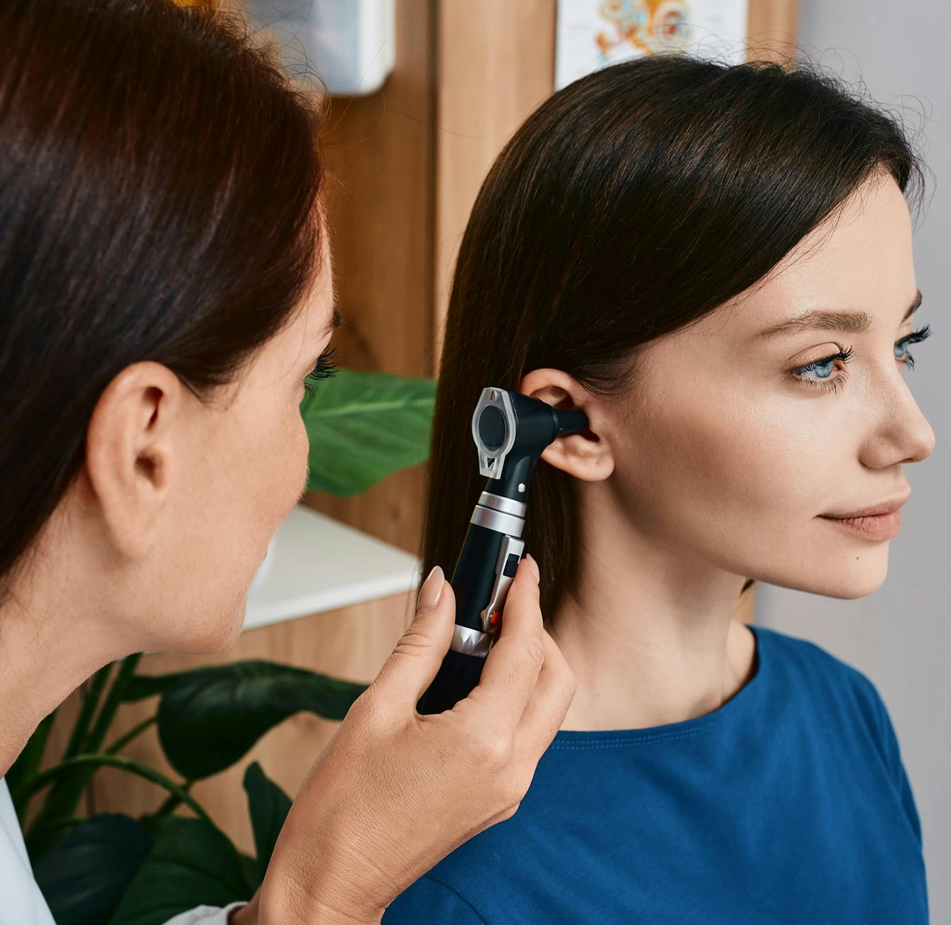 Doctor looking into woman's ear