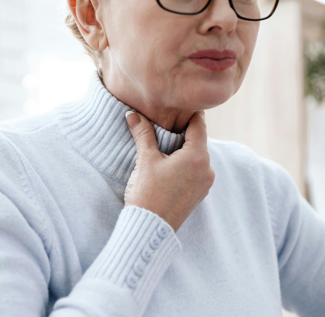 woman touching her throat