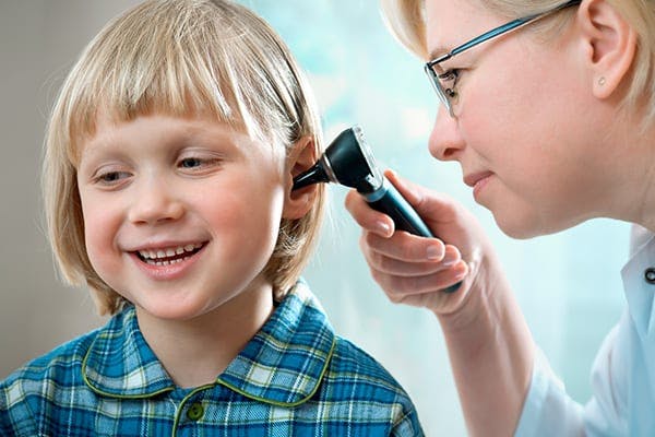 blonde kid getting his ear looked at