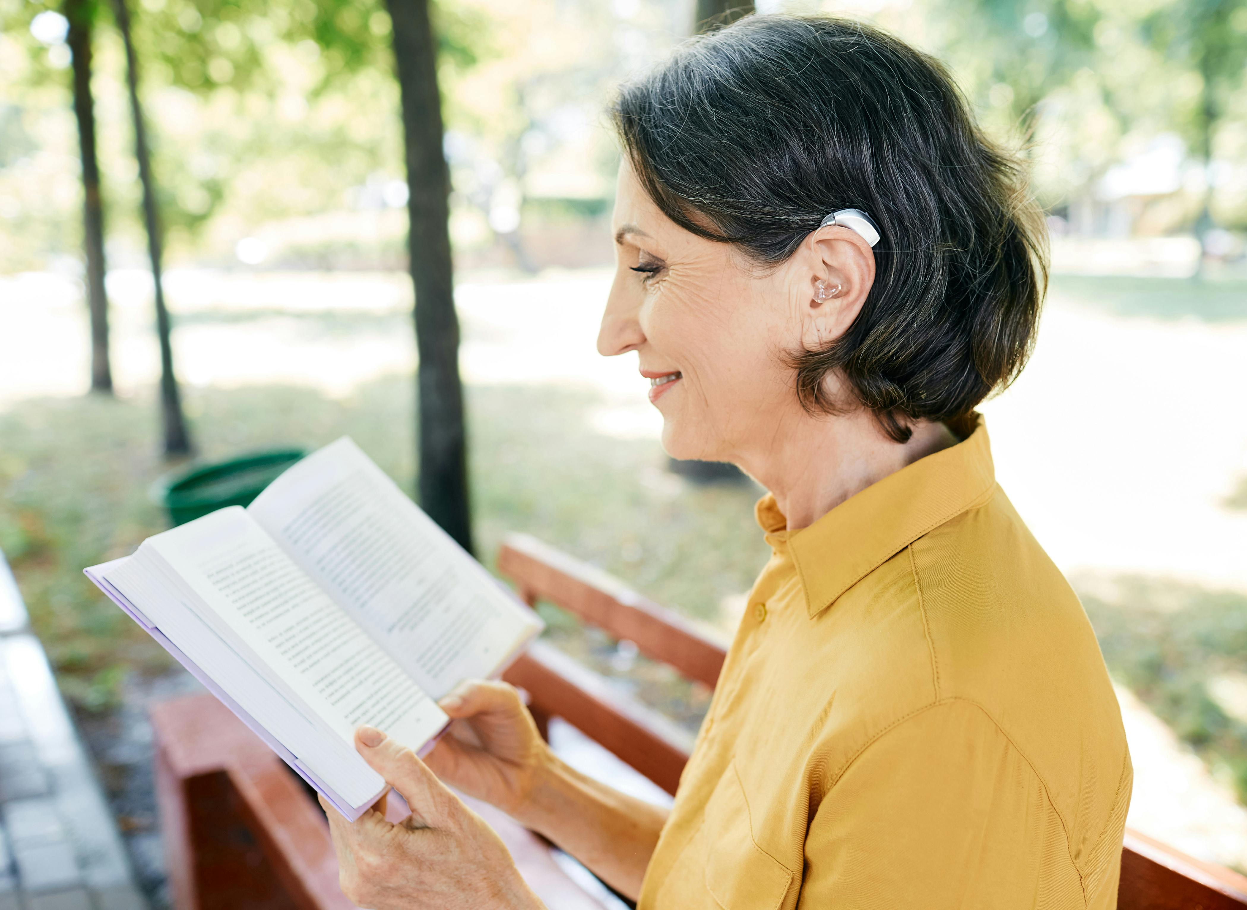 woman with hearing aid reading