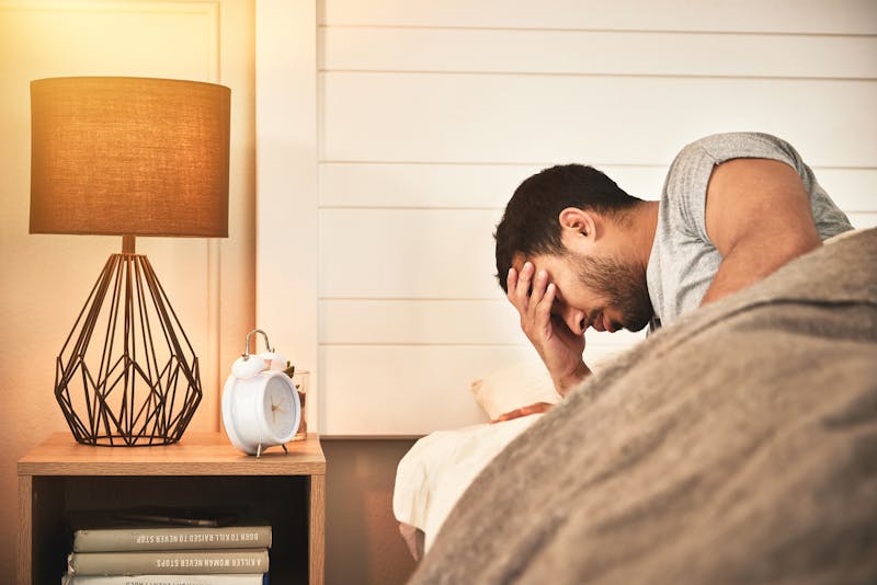 man waking up and holding his head