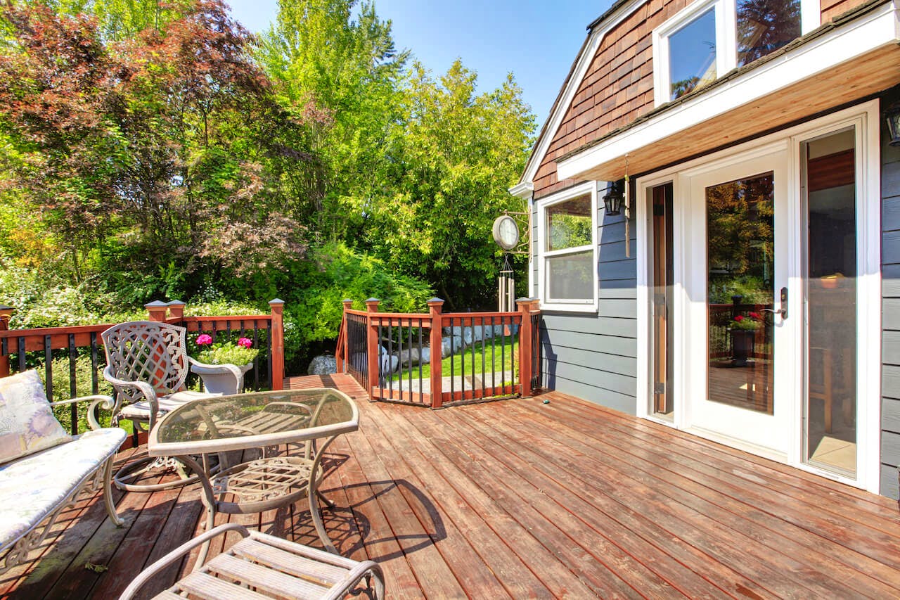 A wooden glass patio door with white trim and a handle, leading out to a patio area.