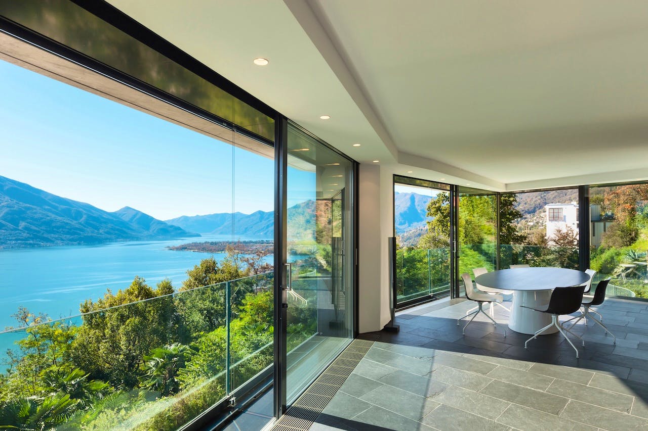 Scenic outdoor view visible through large glass walls, showcasing lush greenery and natural light streaming into the space.