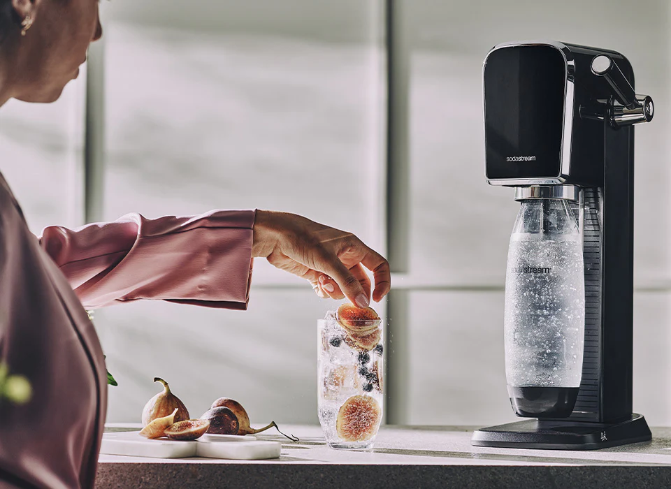Kobieta przygotowująca napój z saturatorem SodaStream Art