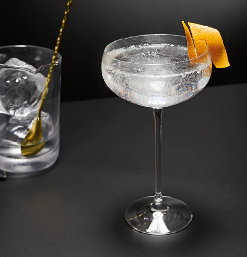 Drink: sake, trawa cytrynowa i wermut ozdobiony spiralką ze skórki grejpfruta