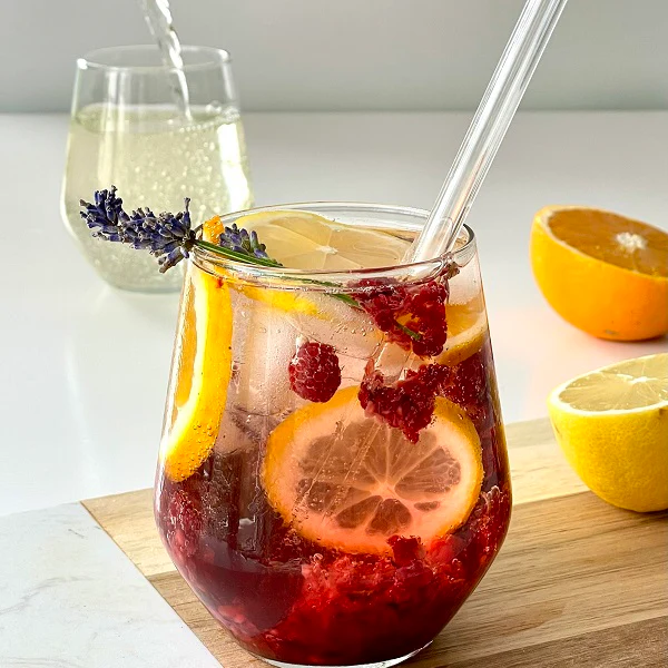Bezalkoholowy drink "Elderflower Raspberry Lemonade" udekorowany kwiatami lawendy