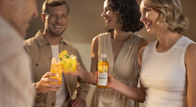 Grupka uśmiechniętych przyjaciół przy mocktailach z syropem SodaStream crafted