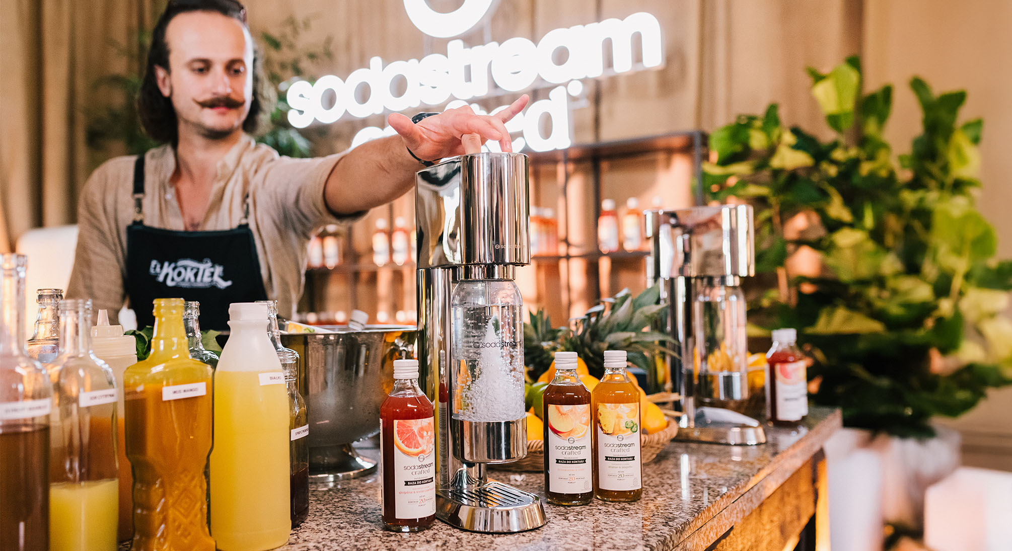 Barman przygotowujący wodę gazowaną w saturatorze SodaStream Enso