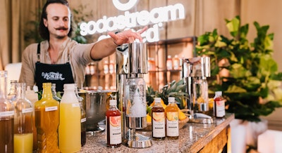 Barman przygotowujący wodę gazowaną w saturatorze SodaStream Enso
