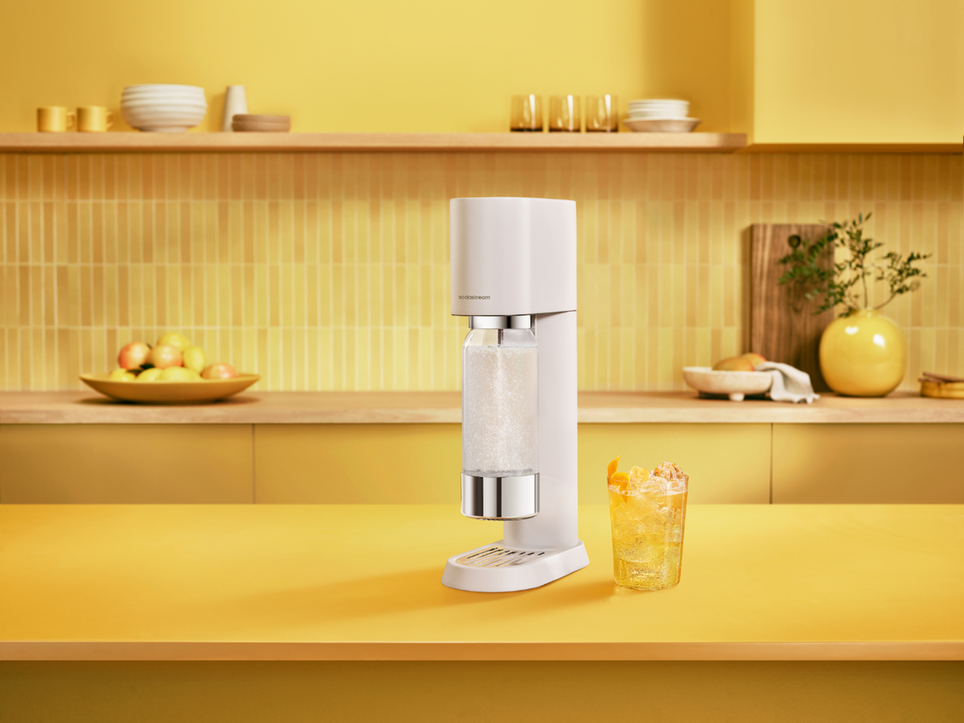 Saturator SodaStream Enso w kolorze białym wyeksponowany w żółtej kuchni.