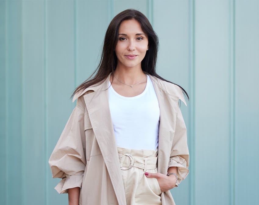 Woman in coat against blue wall