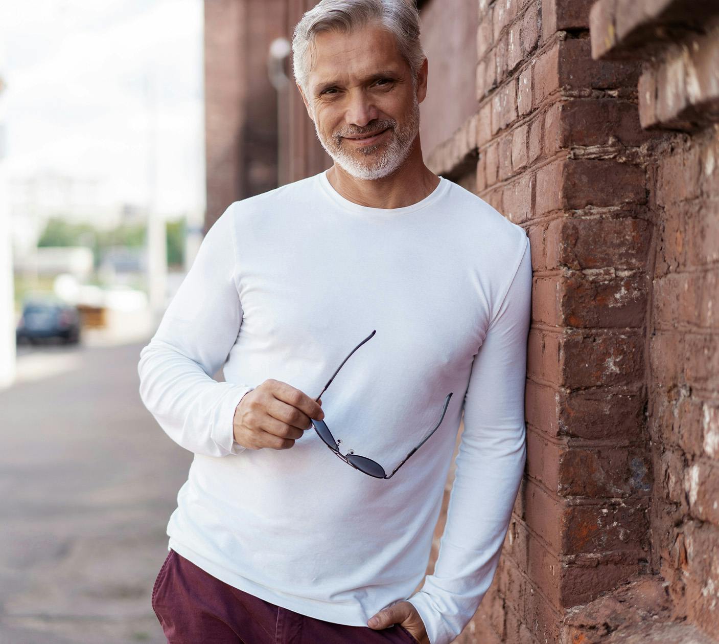 Man leaning against brick wall