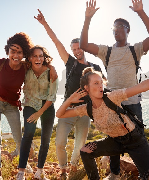 College group posing on hill with scenic background