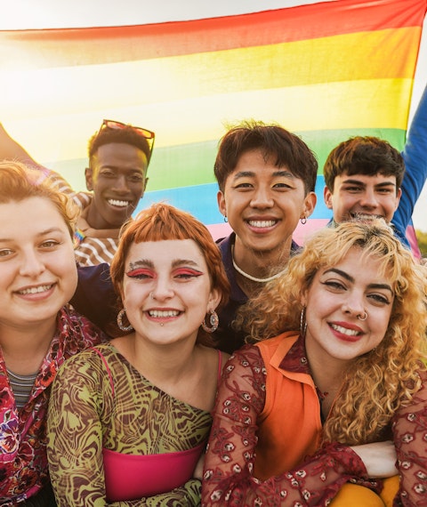 Mixed student group with LGBTQ flag