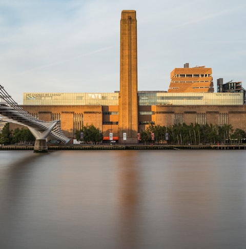 A view across the River Thames with the Millennium Bridge to the right and Tate Modern in front