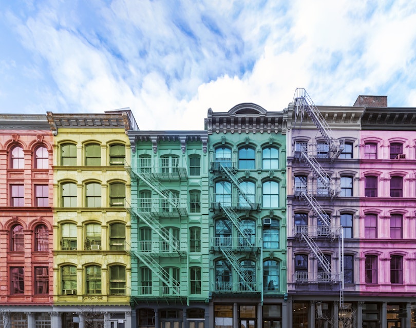 Exterior view of traditional New York apartment buildings that are painted to resemble a rainbow
