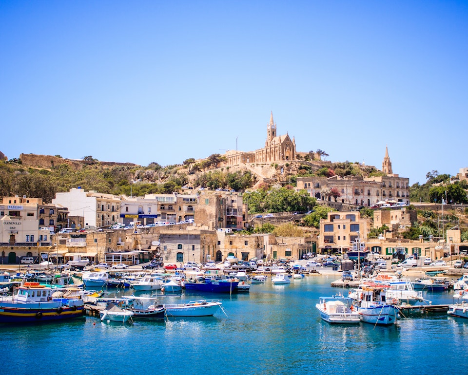 Harbour at Gozo Island, Malta, featuring boats and a view of the church