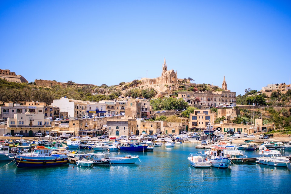 Harbour at Gozo Island, Malta, featuring boats and a view of the church